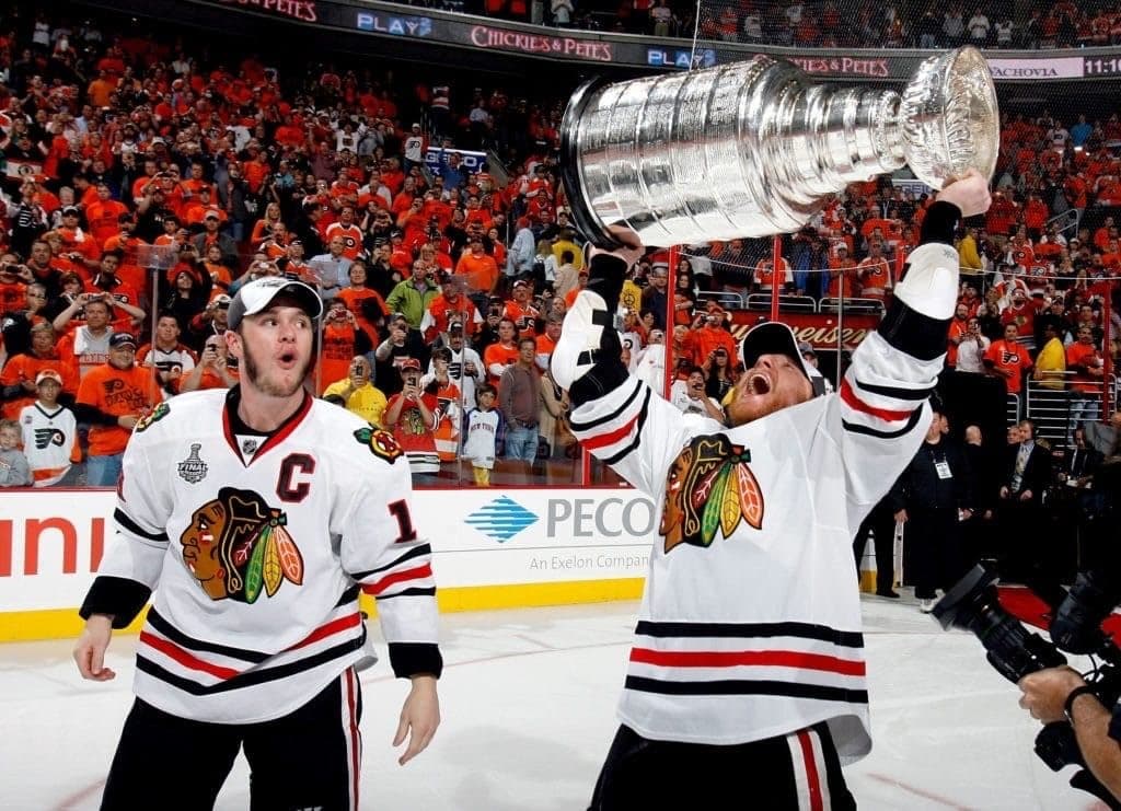 Chicago Blackhawks players hoist the Stanley Cup over their head in victory.